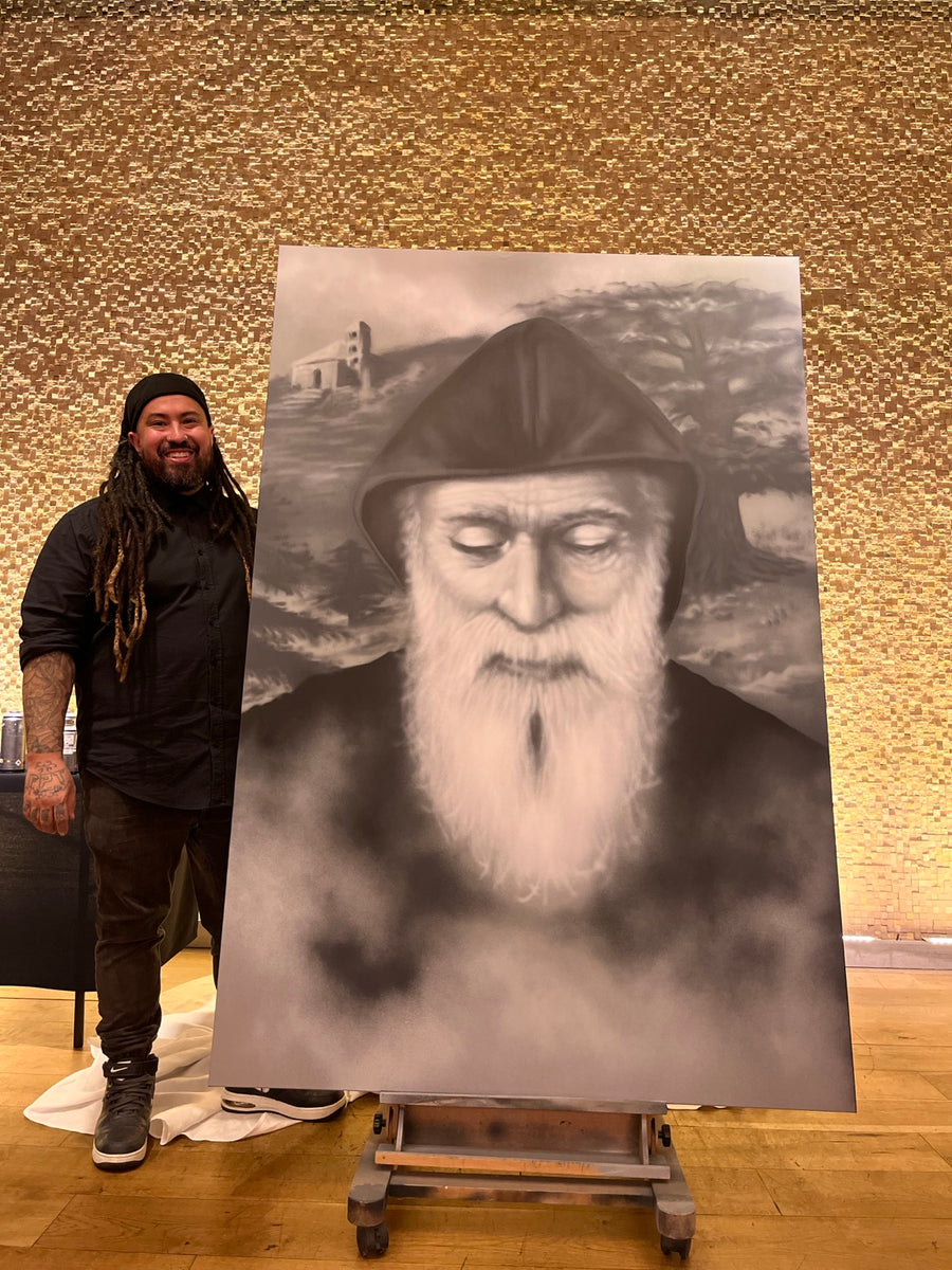 Danny DMuly Mulyono standing beside his completed large Saint Charbel portrait at a live event
