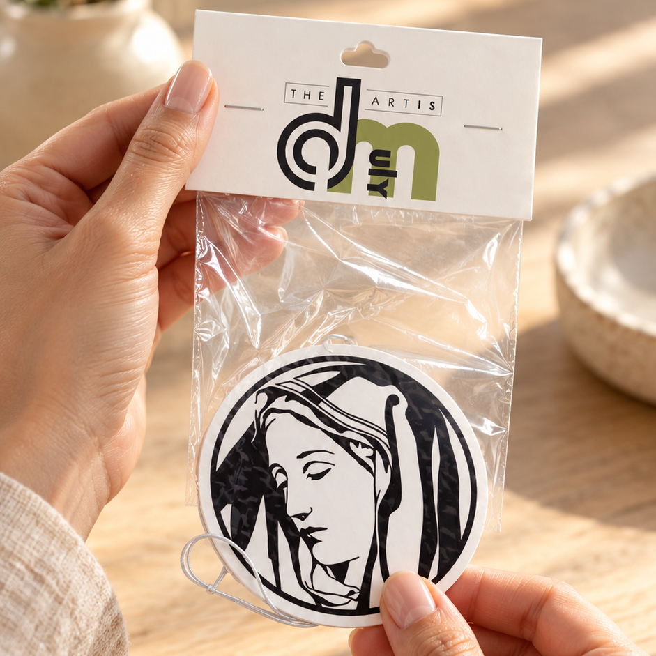 Mother Mary car air freshener being removed from DMuly retail packaging